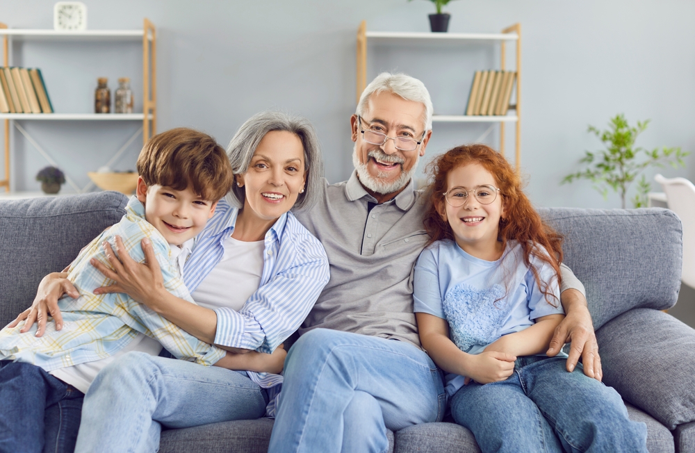 Portrait,Of,A,Happy,Grandparents,Sitting,On,Sofa,With,Their